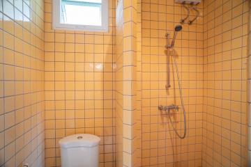 Bright bathroom with yellow tiles, shower and toilet