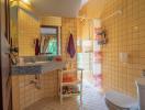 Spacious bathroom with yellow tiles, modern fixtures, and natural light