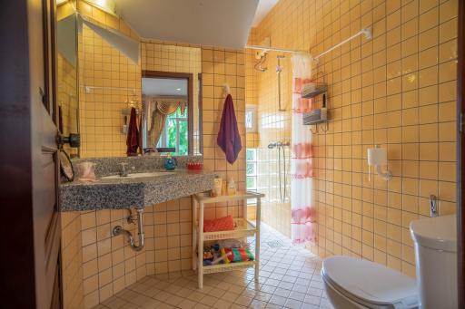 Spacious bathroom with yellow tiles, modern fixtures, and natural light