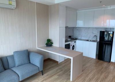 Compact living area with seating and integrated kitchenette featuring modern appliances
