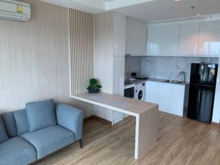 Compact living area with seating and integrated kitchenette featuring modern appliances