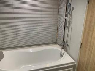 Modern bathroom with white bathtub and aluminum blinds