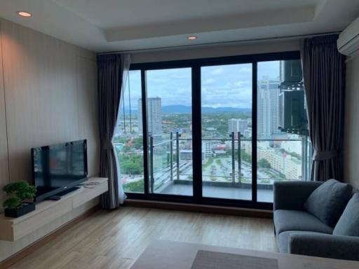 Spacious living room with large windows offering city view