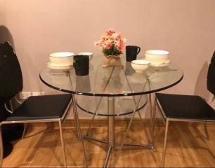 Modern dining area with glass table and flower centerpiece