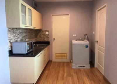 Compact kitchen with modern appliances and tiled backsplash