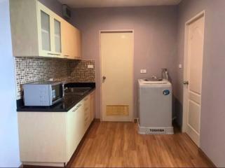 Compact kitchen with modern appliances and tiled backsplash