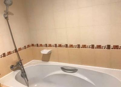 Spacious bathroom with tiled walls and bathtub