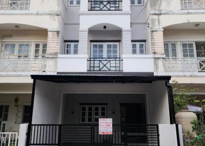 Three-story residential townhouse with a gated entrance