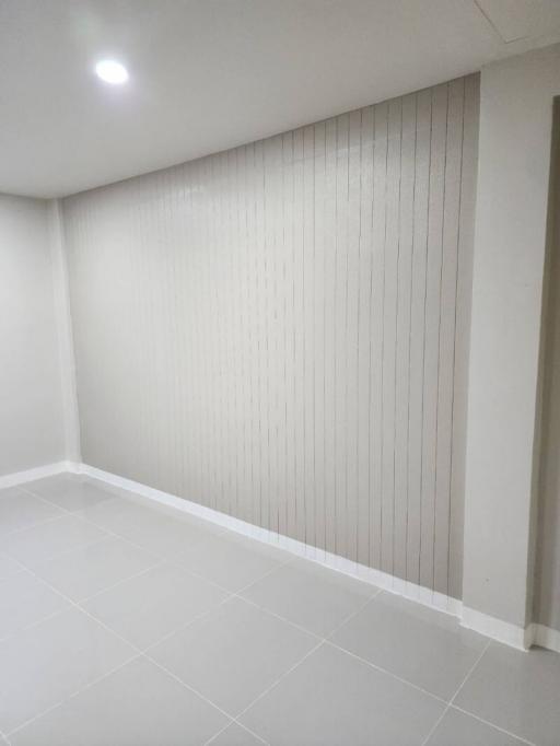 Spacious and well-lit empty room with white walls and tiled flooring