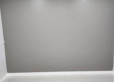 Empty room with white tiled flooring and grey walls