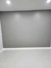 Empty room with white tiled flooring and grey walls