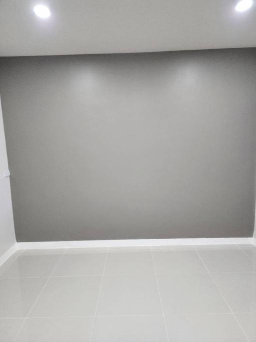 Empty room with white tiled flooring and grey walls