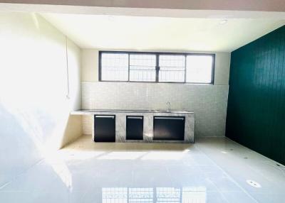 Bright empty kitchen with tile flooring and large window