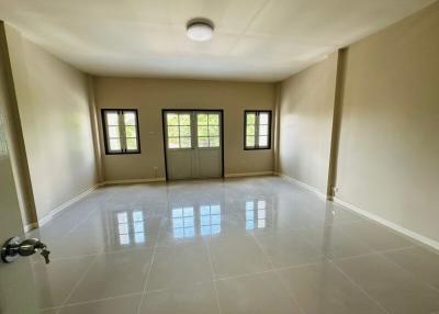 Spacious and well-lit empty living room with glossy tiled flooring