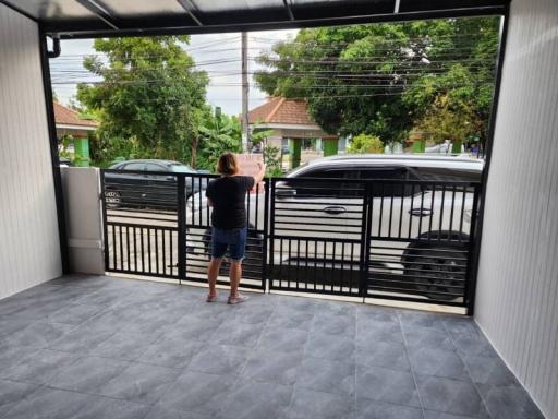 Front entrance of a home with a person standing by the open gate
