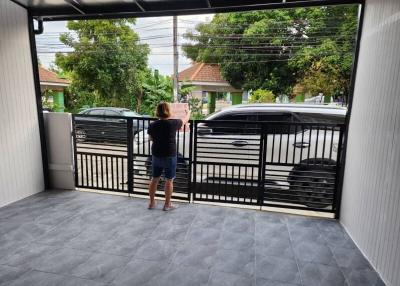 Front entrance of a home with a person standing by the open gate