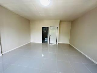 Spacious unfurnished room with glossy tiled flooring and a glass door