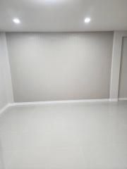 Empty white room with tiled flooring and recessed lighting