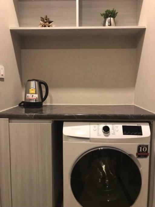 Compact laundry room with washing machine and built-in shelving