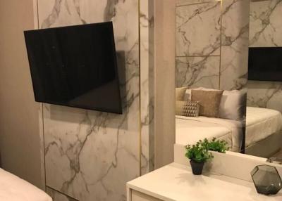 Cozy bedroom interior with marble wall and mounted television