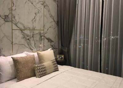 Cozy bedroom with king-sized bed and elegant marble wall detailing