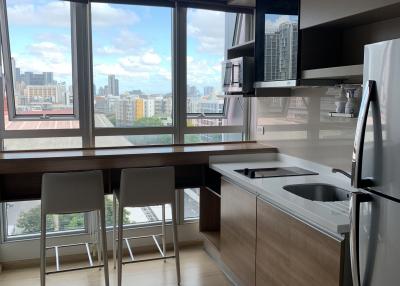 Modern kitchen with city view, stainless steel appliances, and breakfast bar