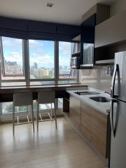 Modern kitchen with city view, stainless steel appliances, and breakfast bar