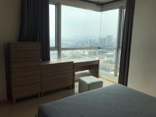 Spacious bedroom with large window offering city views