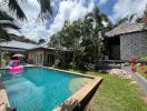 Tropical backyard with swimming pool and surrounding garden