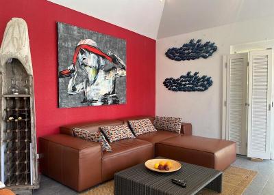 Modern living room with red accent wall and contemporary art