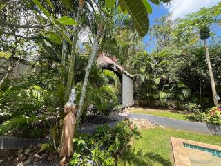 Lush garden entrance with statues and a pathway