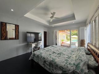 Spacious bedroom with modern amenities and pool view