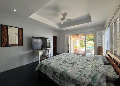 Spacious bedroom with modern amenities and pool view