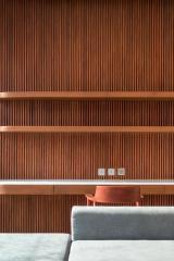 Stylish living room with wooden slat walls and minimalist shelving