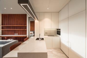 Modern kitchen with integrated appliances and marble flooring