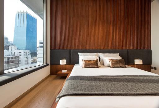 Modern bedroom with large windows and city view