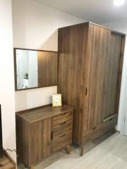 Spacious wooden wardrobe with attached mirror and matching drawer in a modern bedroom