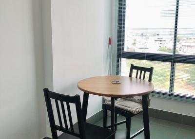 Small dining area with a round table and two chairs by the window