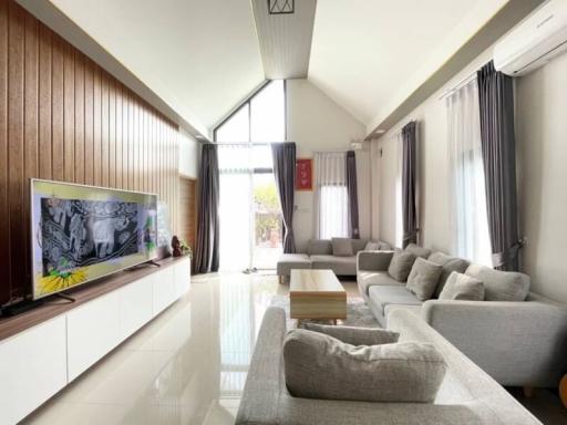 Spacious and modern living room with large windows and elegant furnishings