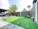 Spacious backyard with artificial grass, patio area, and a carport on a sunny day