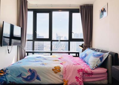 Cozy bedroom with large windows and city view
