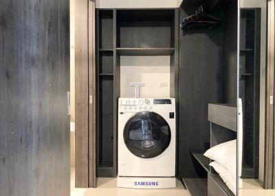 Compact laundry room with modern Samsung washing machine and built-in cabinets