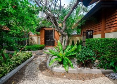Charming house exterior with lush landscaping and pebbled pathway
