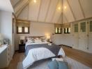 Spacious and bright attic bedroom with large bed and high ceilings