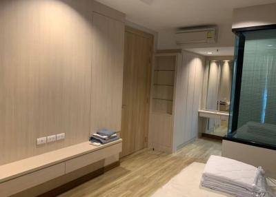 Modern bedroom with built-in wardrobes and wood flooring