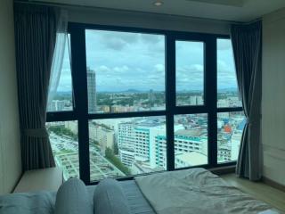 Bright bedroom with large window and city view