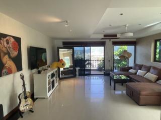 Spacious living room with modern furnishings, a large leather sofa, and glossy tiled flooring