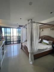 Spacious bedroom with a large bed and panoramic window