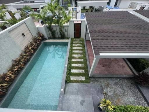 Aerial view of a residential outdoor area featuring a swimming pool, garden, and patio