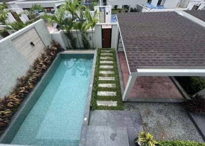 Aerial view of a residential outdoor area featuring a swimming pool, garden, and patio